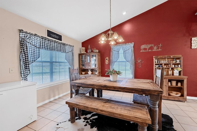 dining space with light tile patterned floors, baseboards, an inviting chandelier, and lofted ceiling
