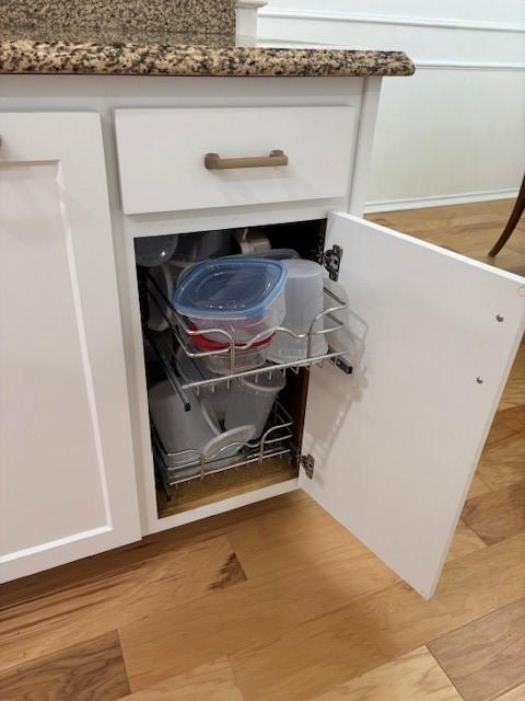 interior details featuring light wood-style floors and white cabinetry