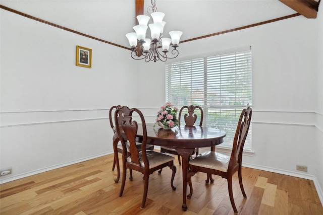 dining room featuring ornamental molding, baseboards, light wood-type flooring, and a chandelier