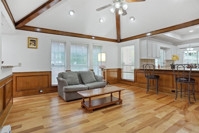 living room with light wood-style floors, wainscoting, and a wealth of natural light