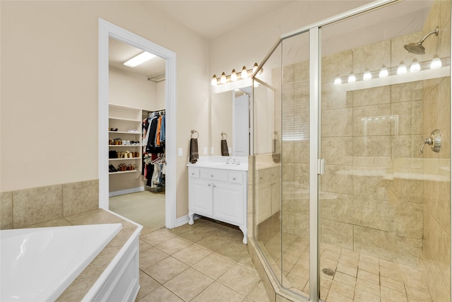 full bath featuring a shower stall, vanity, a bath, tile patterned flooring, and a spacious closet