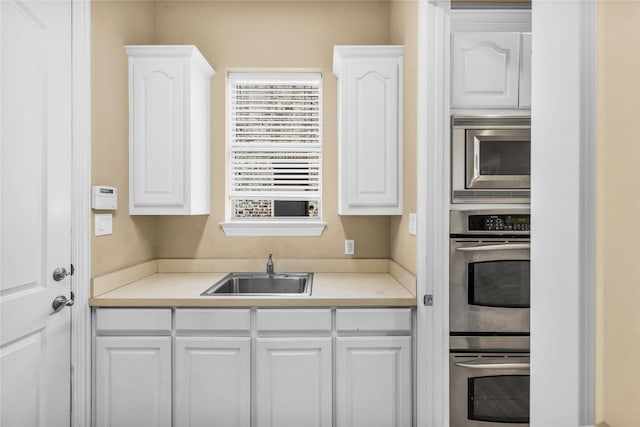 kitchen featuring a sink, white cabinetry, appliances with stainless steel finishes, and light countertops
