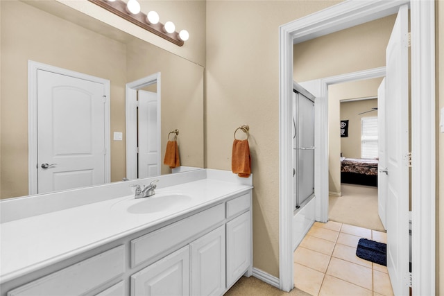 full bath featuring tile patterned flooring, vanity, a shower with shower door, and baseboards