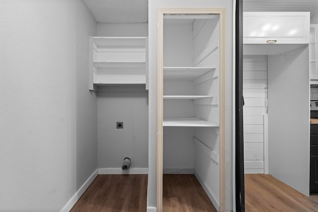 laundry area featuring electric dryer hookup, laundry area, dark wood-style floors, and baseboards