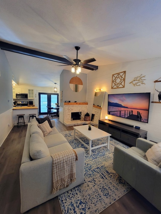 living area with a ceiling fan, wood finished floors, and a brick fireplace