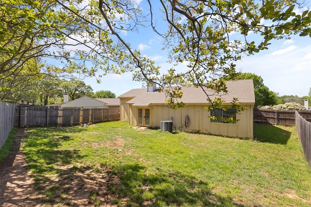 rear view of house featuring a shingled roof, french doors, a fenced backyard, a yard, and cooling unit