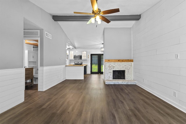 unfurnished living room featuring visible vents, vaulted ceiling with beams, ceiling fan, and wood walls