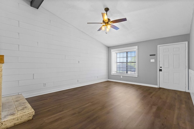 unfurnished living room with baseboards, vaulted ceiling, ceiling fan, and dark wood-style flooring