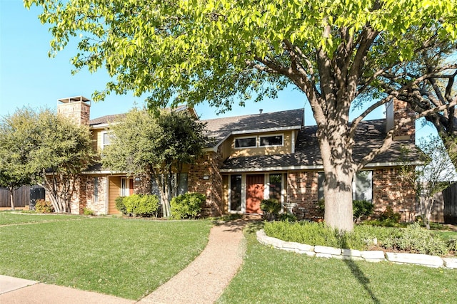 view of front facade with a chimney, fence, and a front lawn