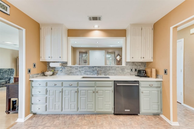 kitchen with visible vents, a sink, light countertops, stainless steel dishwasher, and decorative backsplash