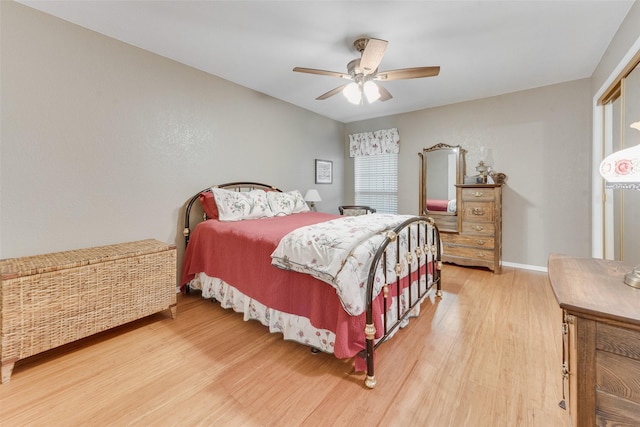 bedroom with wood finished floors, baseboards, and a ceiling fan