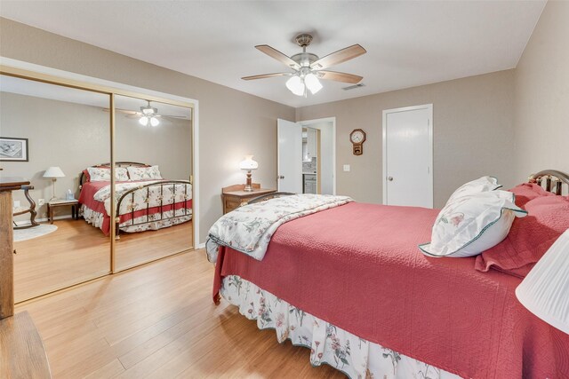 bedroom featuring a closet, wood finished floors, a ceiling fan, and visible vents