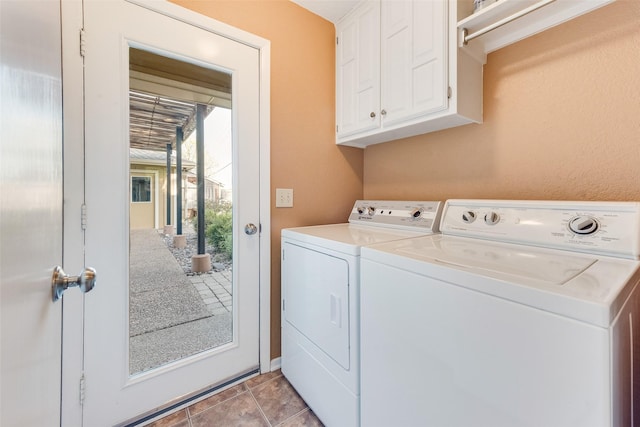 washroom featuring cabinet space, washer and clothes dryer, and light tile patterned flooring
