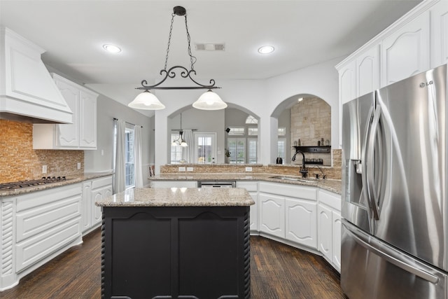 kitchen with custom range hood, a wealth of natural light, visible vents, appliances with stainless steel finishes, and a sink