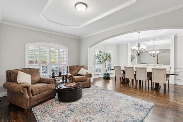 living room with dark wood-type flooring, arched walkways, and plenty of natural light