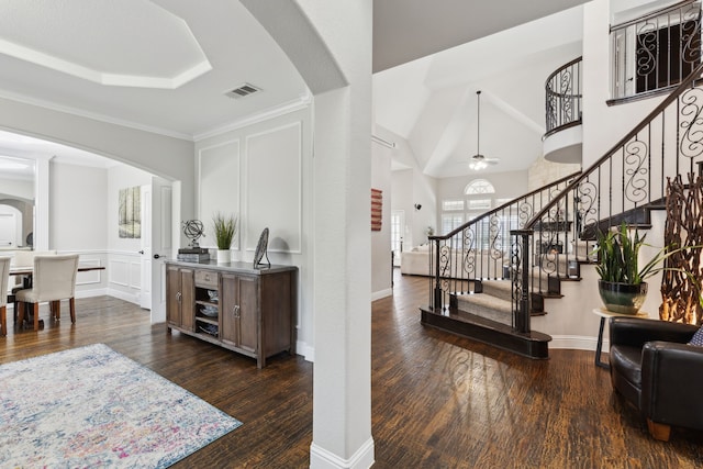 interior space with a decorative wall, visible vents, arched walkways, and wood finished floors