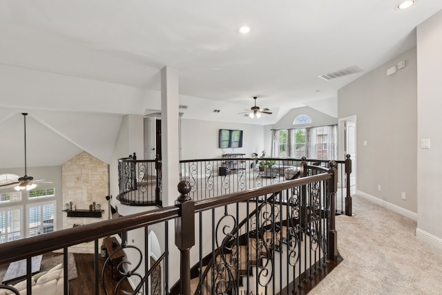 hall with visible vents, baseboards, an upstairs landing, carpet flooring, and lofted ceiling