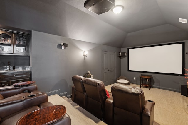 cinema room featuring bar area, visible vents, vaulted ceiling, a sink, and baseboards