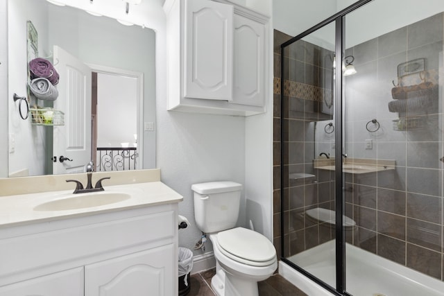 bathroom with a shower stall, vanity, and toilet