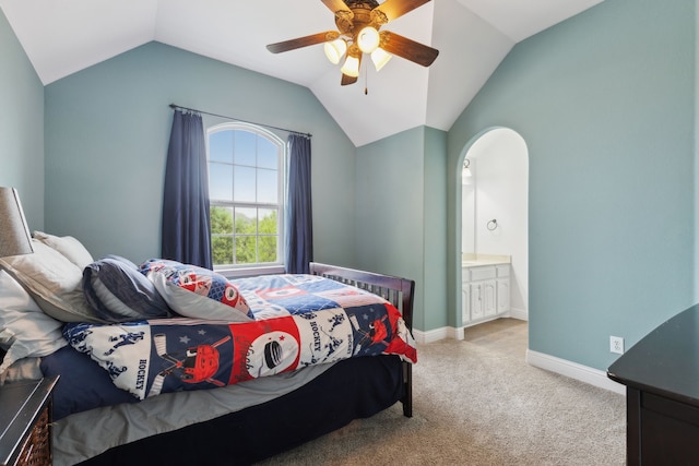 bedroom featuring ensuite bath, a ceiling fan, light carpet, lofted ceiling, and baseboards