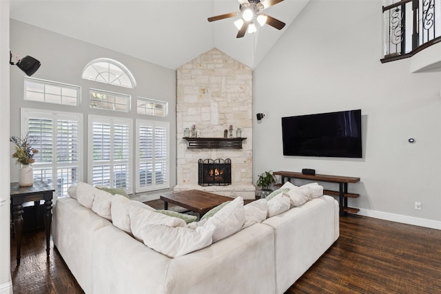 living area with baseboards, a fireplace, ceiling fan, high vaulted ceiling, and wood finished floors