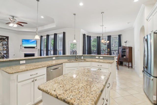 kitchen with light tile patterned floors, a sink, light stone countertops, a center island, and appliances with stainless steel finishes