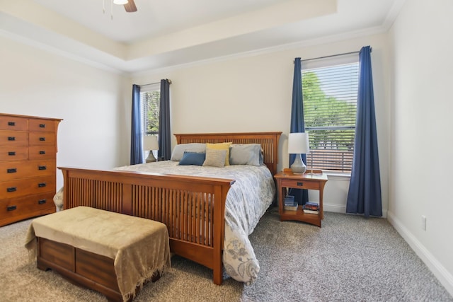 bedroom with baseboards, a ceiling fan, a tray ceiling, and carpet floors