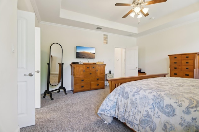 bedroom with a raised ceiling, carpet floors, a ceiling fan, and ornamental molding