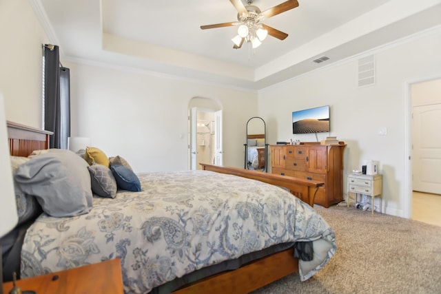 bedroom with arched walkways, a raised ceiling, carpet, and visible vents