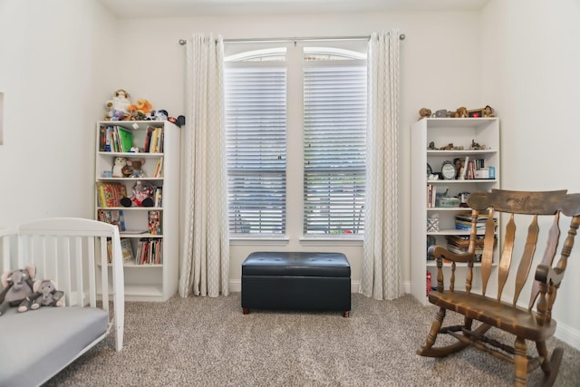 carpeted bedroom featuring a nursery area