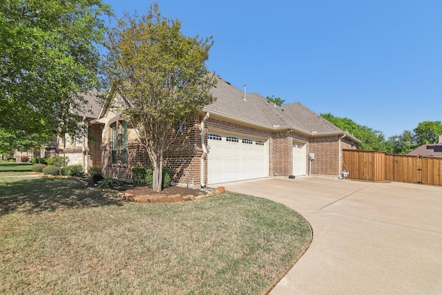 view of front of house with a gate, a front lawn, concrete driveway, brick siding, and a garage