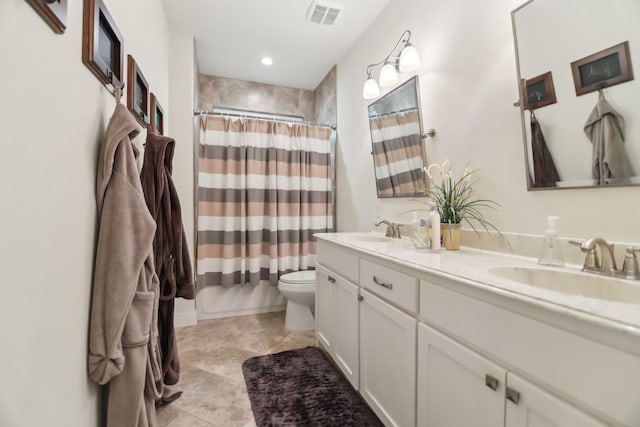 bathroom with visible vents, a sink, double vanity, and toilet