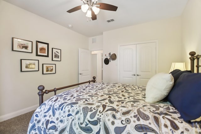 carpeted bedroom featuring a closet, visible vents, baseboards, and ceiling fan
