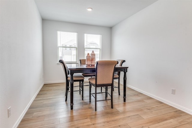 dining area with baseboards and light wood-type flooring