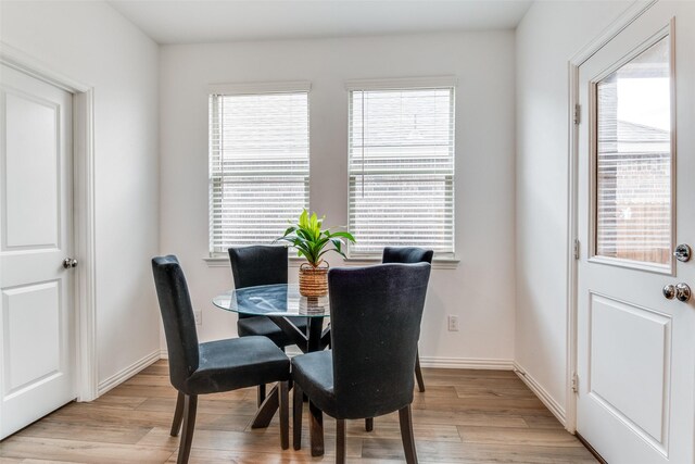 dining space with a wealth of natural light and light wood-type flooring