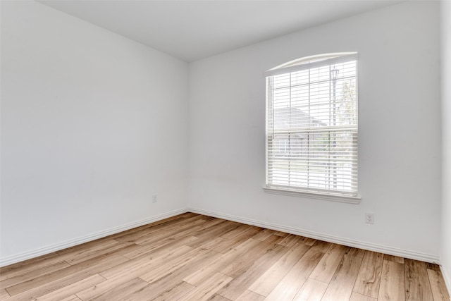 empty room featuring baseboards and light wood-type flooring
