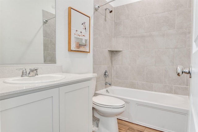 full bathroom featuring wood finished floors, toilet, shower / bathtub combination, and vanity