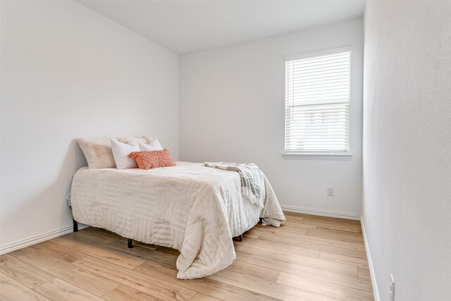 bedroom with light wood-style floors and baseboards