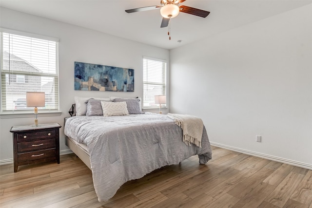 bedroom with baseboards, a ceiling fan, and light wood finished floors
