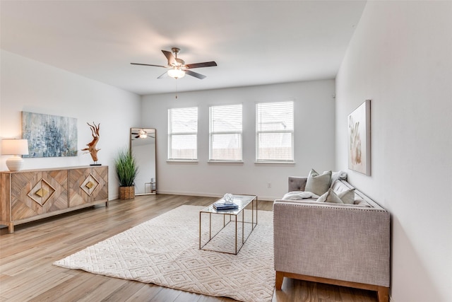sitting room featuring ceiling fan, wood finished floors, and baseboards