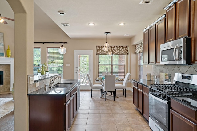 4134 Lee Hutson Dr, Sachse, TX 75048 - kitchen with appliances with stainless steel finishes, visible vents, dark stone counters, decorative backsplash, and a sink