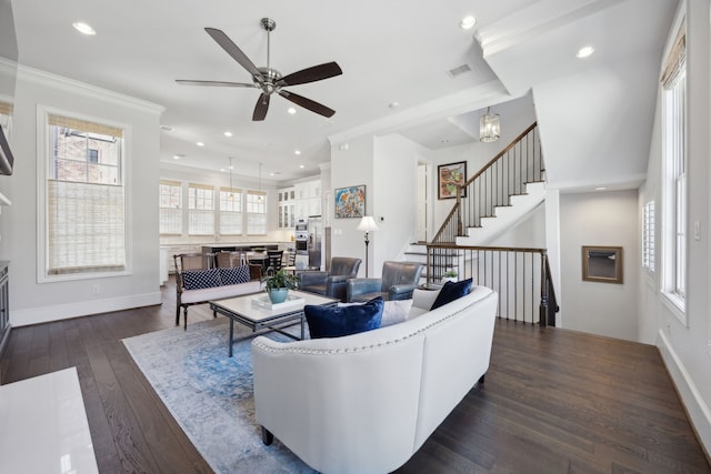 living room featuring visible vents, plenty of natural light, crown molding, and dark wood-style floors