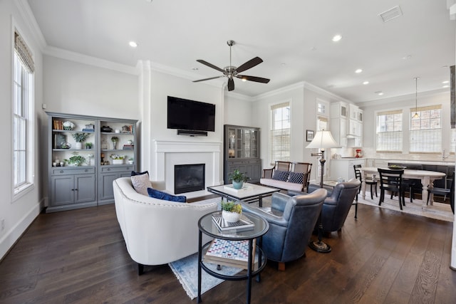 living room with visible vents, recessed lighting, a glass covered fireplace, and dark wood-style floors