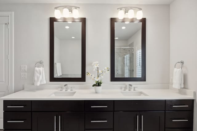 full bath featuring double vanity, a sink, and a stall shower