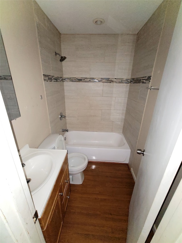 bathroom featuring toilet, shower / bath combination, wood finished floors, and vanity