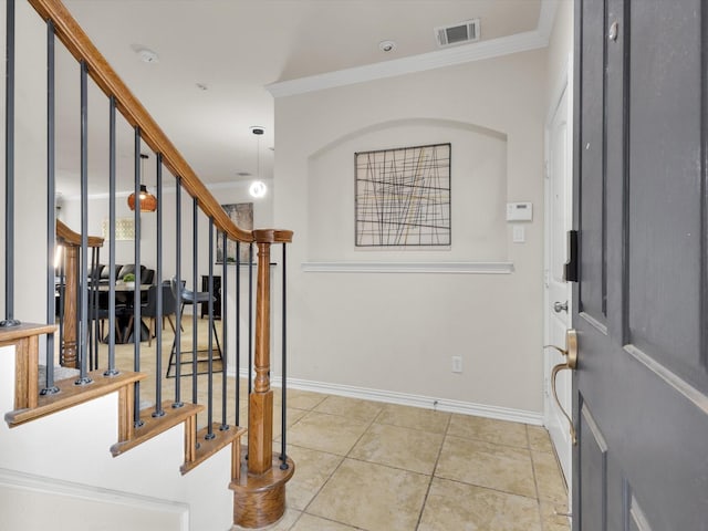 foyer with ornamental molding, visible vents, stairway, and light tile patterned floors