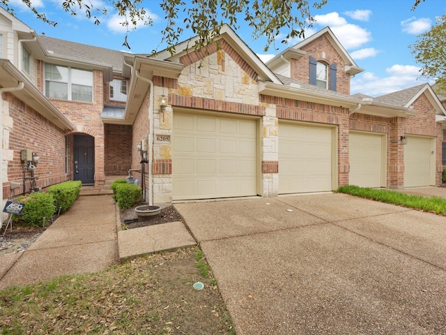 6205 Shoal Creek Trl, Garland, TX 75044 - view of property featuring concrete driveway, brick siding, stone siding, and a shingled roof