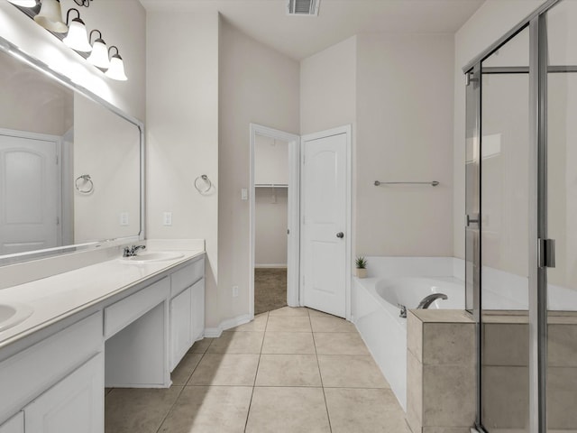 bathroom featuring a bath, a sink, double vanity, tile patterned flooring, and a stall shower