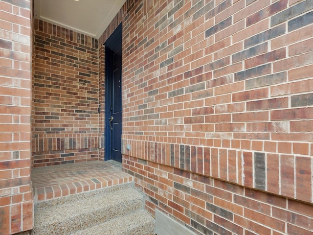 doorway to property featuring brick siding