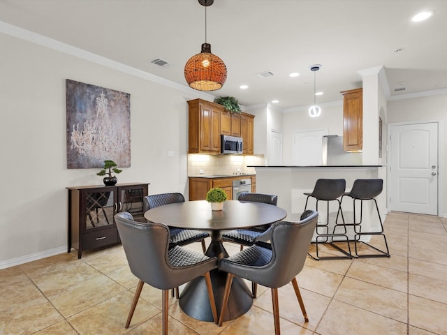 dining room with light tile patterned floors, baseboards, ornamental molding, and visible vents